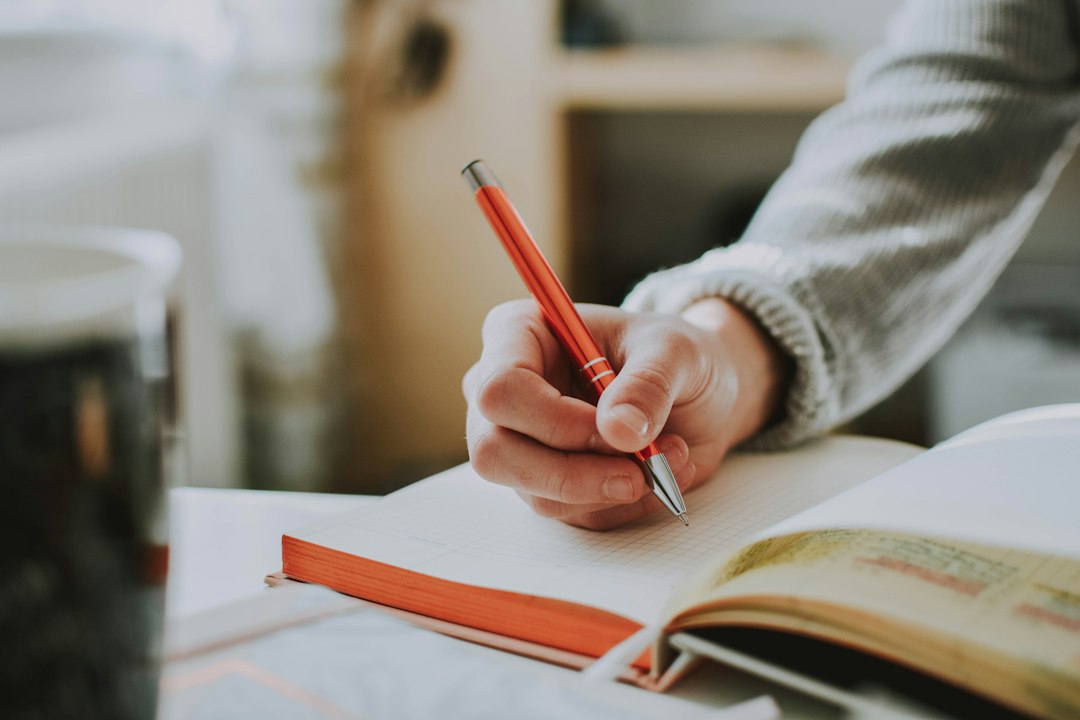 hands writing in notebook — photo by lilartsy on Unsplash